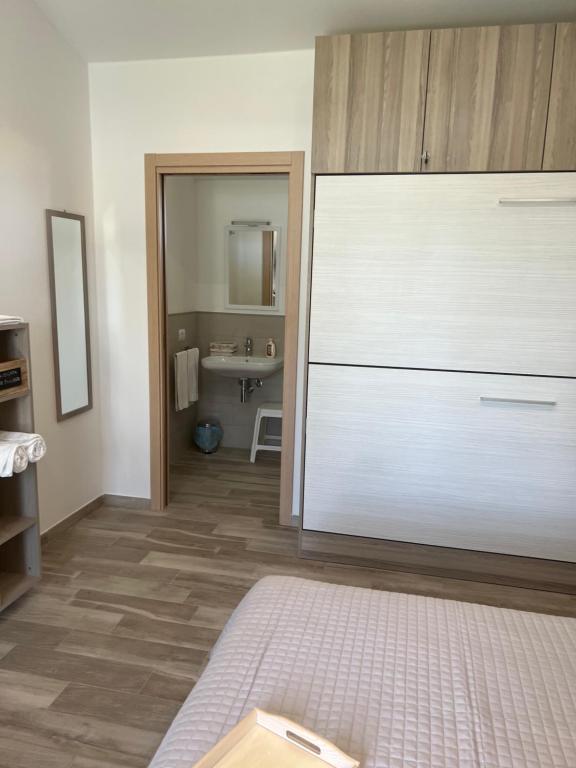 uma casa de banho com uma grande cómoda branca num quarto em Il giardino di nunzia em Principina Terra
