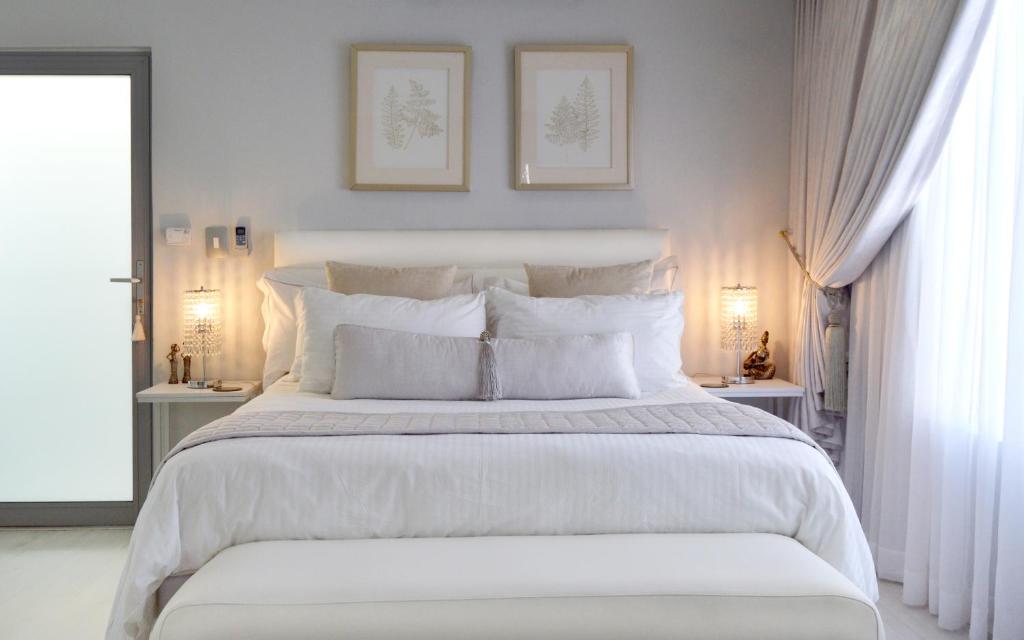 a white bedroom with a large bed with white pillows at Augusta Palms - White Room in Centurion