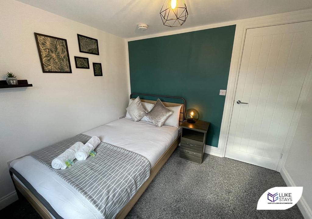 ein Schlafzimmer mit einem Bett mit einer grünen Wand in der Unterkunft Luke Stays - Pembroke Avenue in Walker Gate
