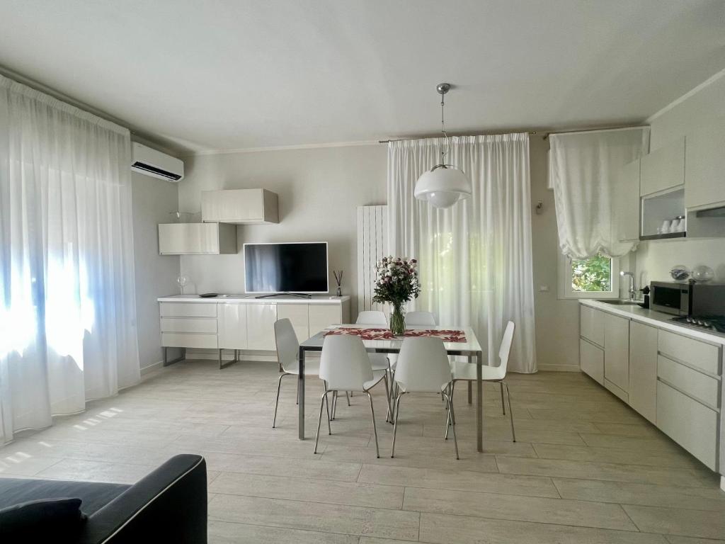cocina y comedor con mesa y sillas en Stunning Apartment 300mt from the beach en Forte dei Marmi