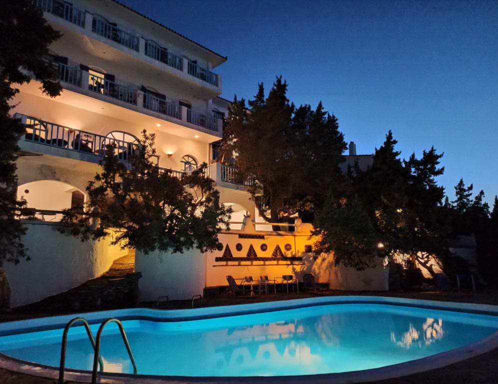 un hotel con piscina frente a un edificio en Daidalos Hotel en Armenistis