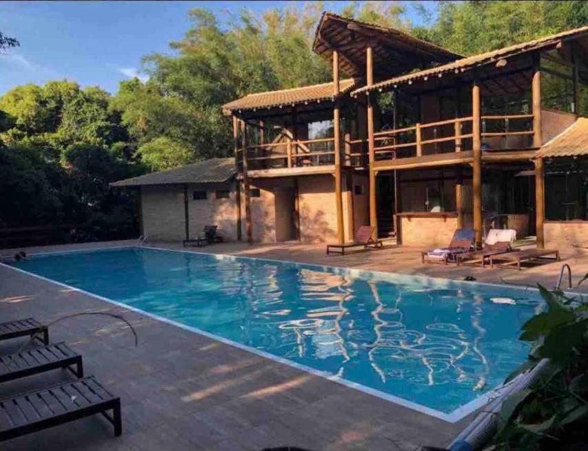 una gran piscina frente a una casa en Casa Pé na Areia, en Pauba