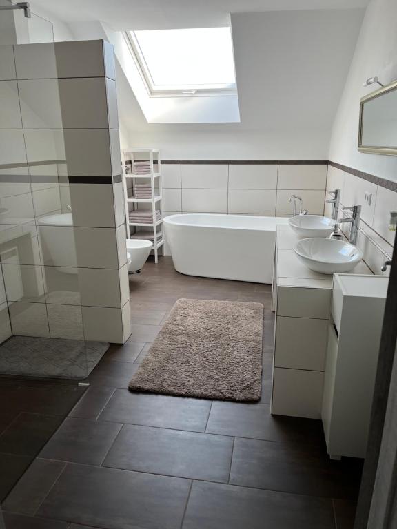 a bathroom with a tub and two sinks and a bath tub at La Casa di Gino in Engelsbrand