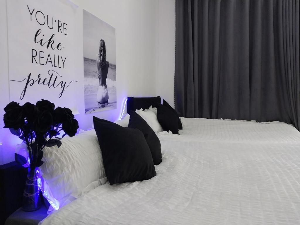 a bedroom with a white bed with black pillows at Triple-T Homestay VTS in Vung Tau