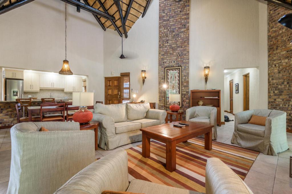 a living room with couches and a table at Kruger Park Lodge Unit No. 547 in Hazyview