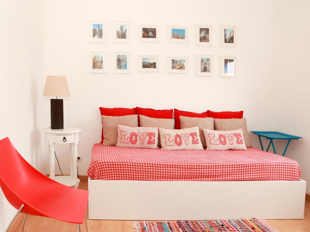 リスボンにあるCasa Encantada - Eliasのベッドルーム1室(ベッド1台、赤い椅子付)