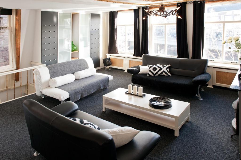Canal Holiday Apartment في أمستردام: غرفة معيشة مع كنب وطاولة قهوة