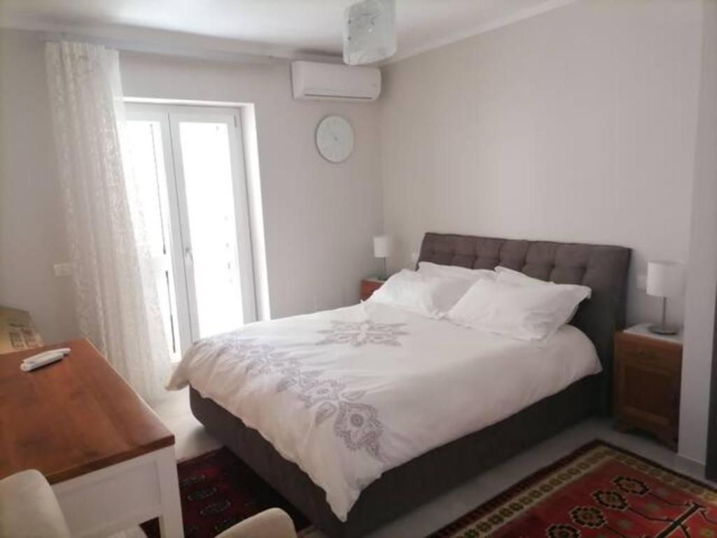a bedroom with a bed and a window with a clock at SoleLuna Apartment 2 in Santa Elisabetta