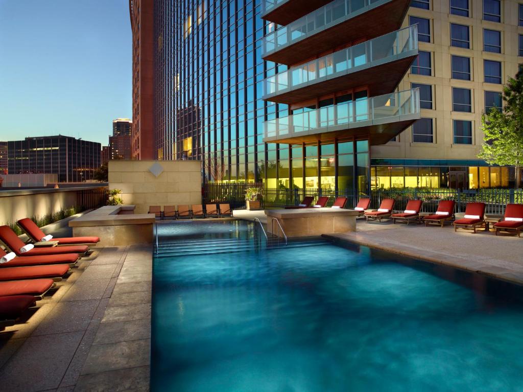 a swimming pool with chairs and a building at Omni Fort Worth Hotel in Fort Worth