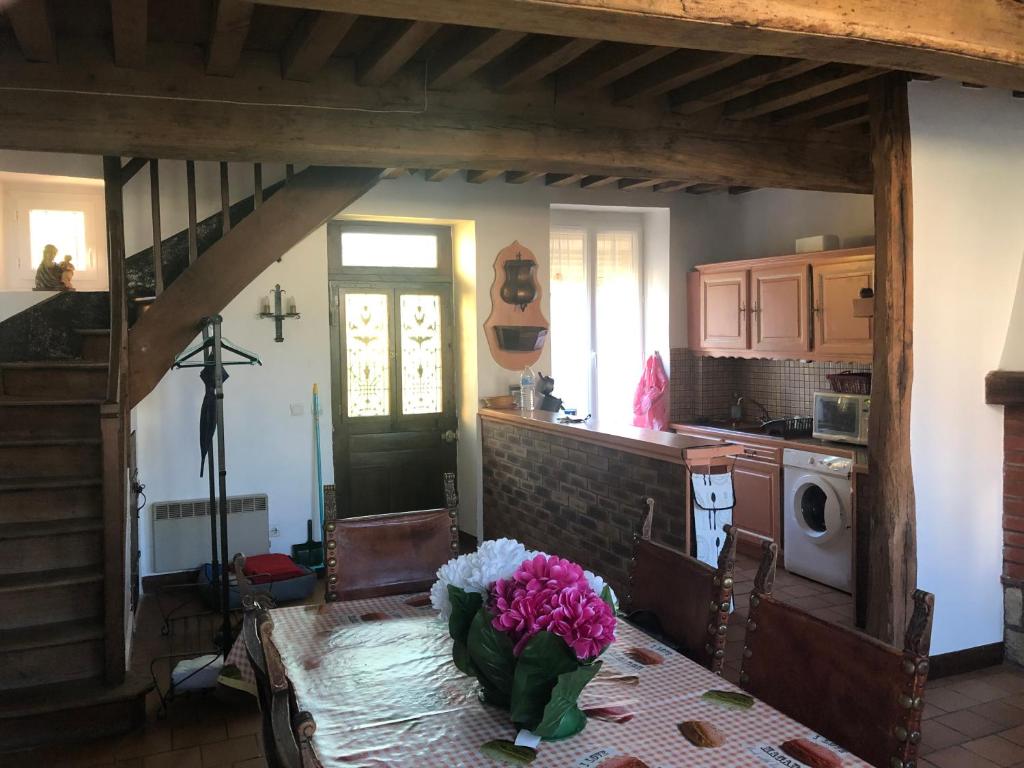 eine Küche mit einem Tisch und einer Blumenvase darauf in der Unterkunft Maison Bourgogne in Château-Chinon