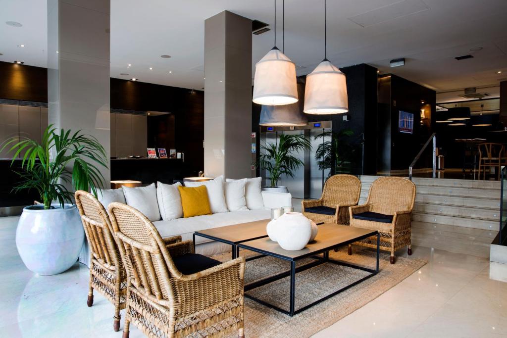 a living room with a white couch and chairs at Zenit Valencia in Valencia