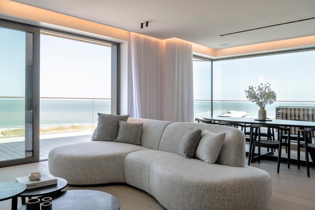 un soggiorno con divano e tavolo con vista di Ostend penthouse beach view private pool a Ostenda