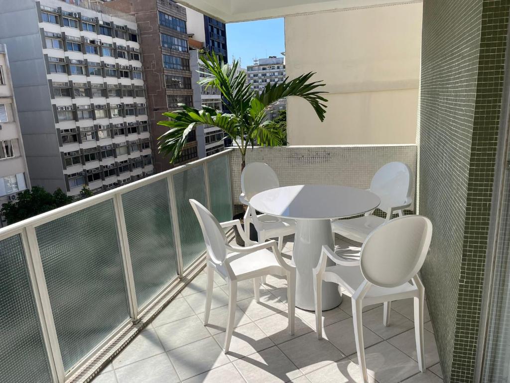 a balcony with a white table and white chairs at Precioso apartamento con terraza y piscina in Rio de Janeiro