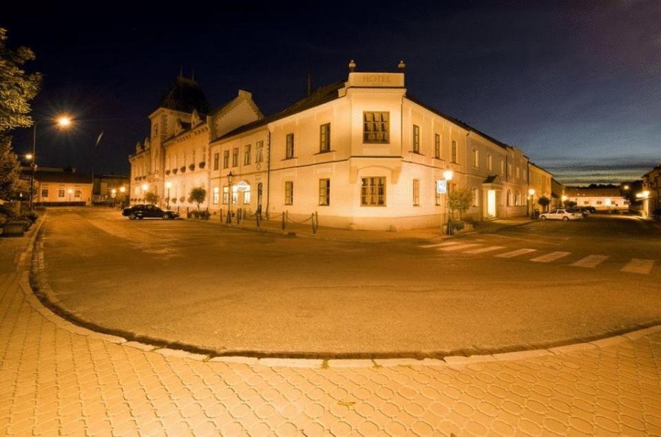 a large white building on a street at night at Hotel Mario in Lednice
