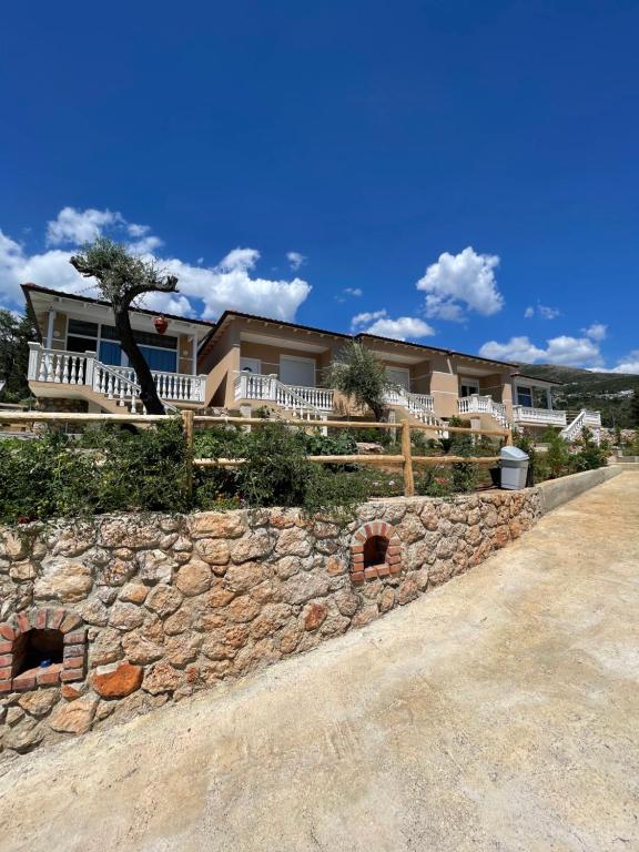 a stone retaining wall in front of a house at Essos Villas in Dhërmi