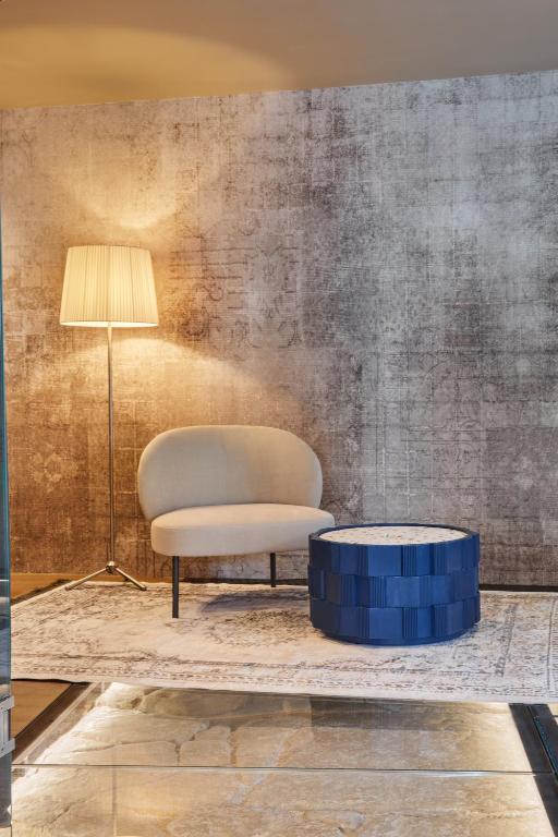a living room with a chair and a table at Martis Forum Heritage Hotel & Residence in Poreč