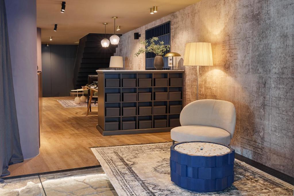 a living room with a chair and a table at Martis Forum Heritage Hotel & Residence in Poreč