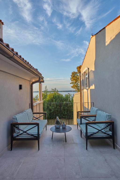 a patio with two couches and a table on a balcony at Martis Forum Heritage Hotel & Residence in Poreč