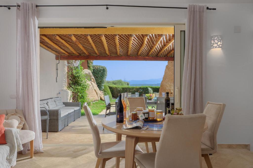 comedor con mesa y sillas en Villetta d'Arancia - SHERDENIA Luxury Apartments, en Marinella