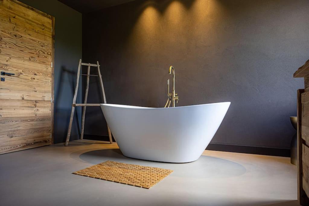 a white bath tub sitting in a room at Le 11 des Bouchaux, Gîte d&#39;exception in La Bresse