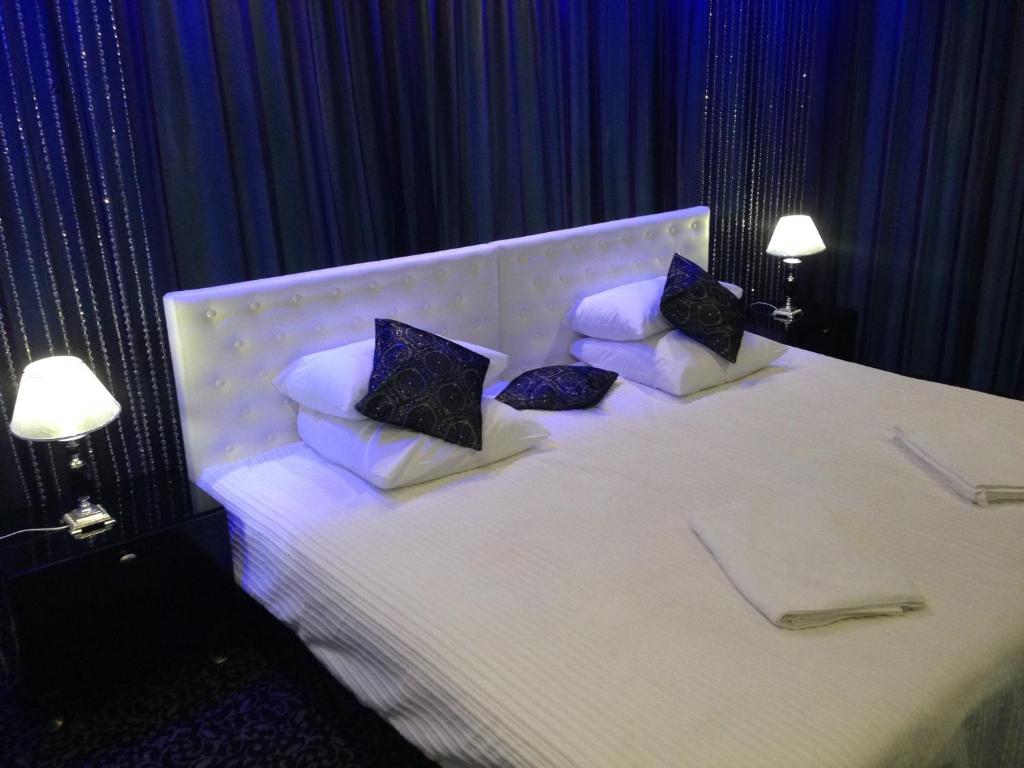 a bedroom with a white bed with three pillows at History Hotel in Vologda