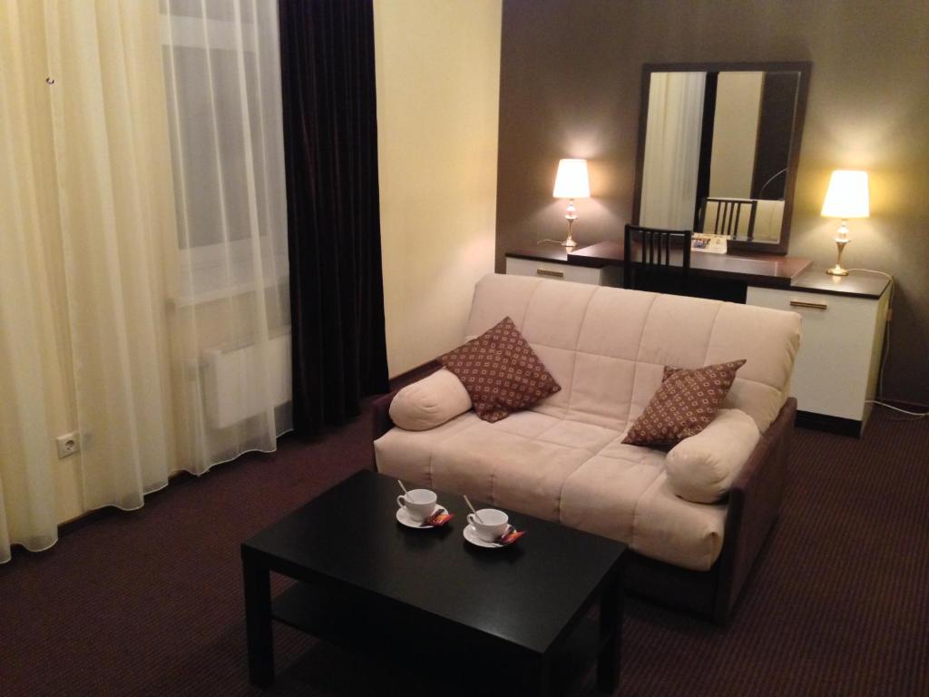 a living room with a couch and a coffee table at History Hotel in Vologda