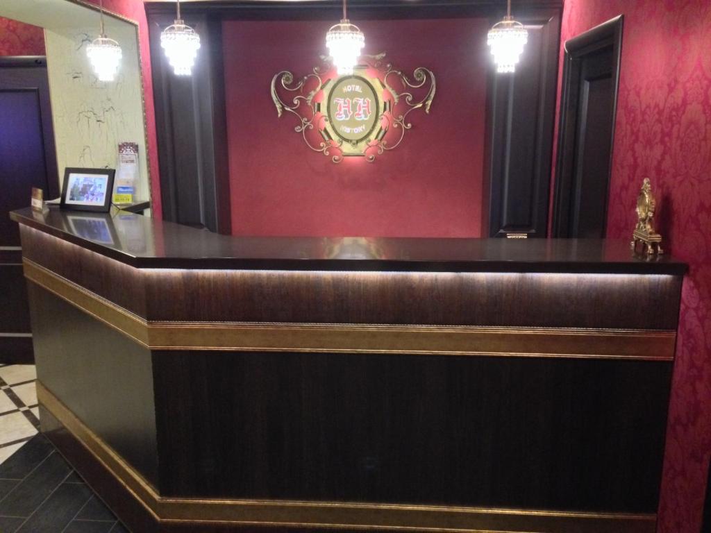 a bar in a restaurant with a red wall at History Hotel in Vologda