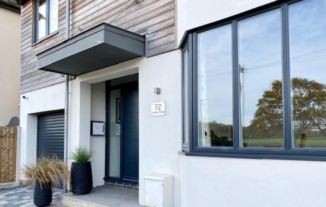 une maison blanche avec une porte et des fenêtres bleues dans l'établissement 72 Ashley Road, à Newmarket