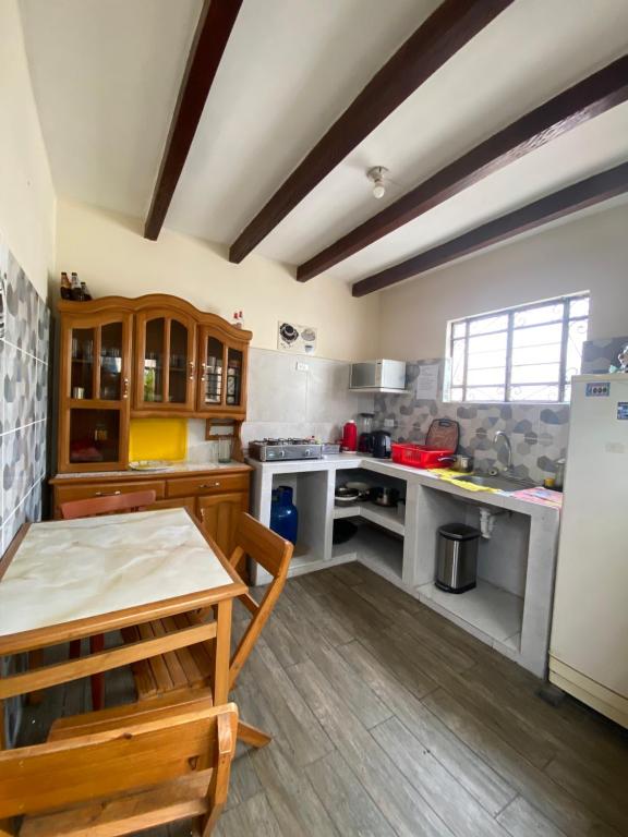een grote keuken met witte werkbladen en een koelkast bij La Chocita Ward in Lima