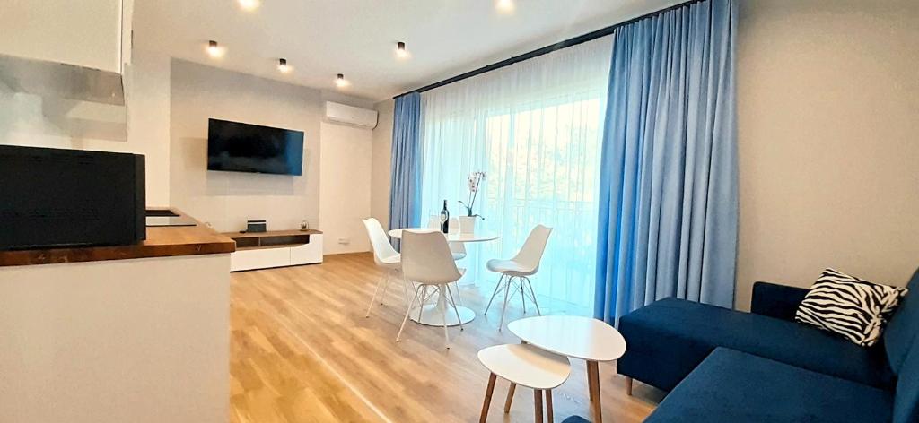 姆龍戈沃的住宿－Masurian Apartments，客厅配有蓝色的沙发和桌子