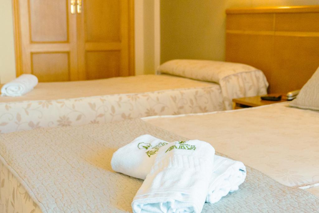 Habitación de hotel con 2 camas y toallas. en Hotel Atalaya I, en Portonovo