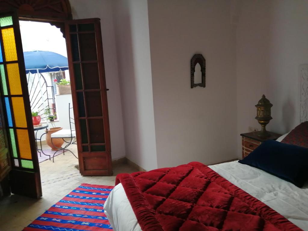 a bedroom with a bed and a door to a patio at Riad Siham in El Jadida