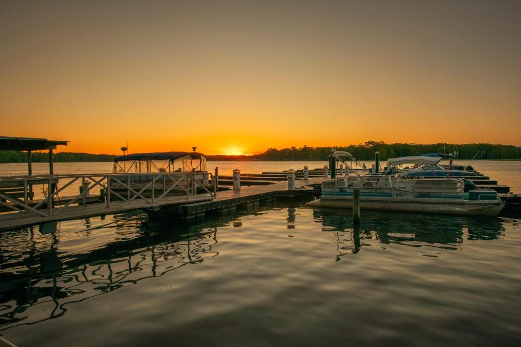 zwei Boote, die bei Sonnenuntergang an einem Dock angedockt sind in der Unterkunft Rivers Rest Resort 