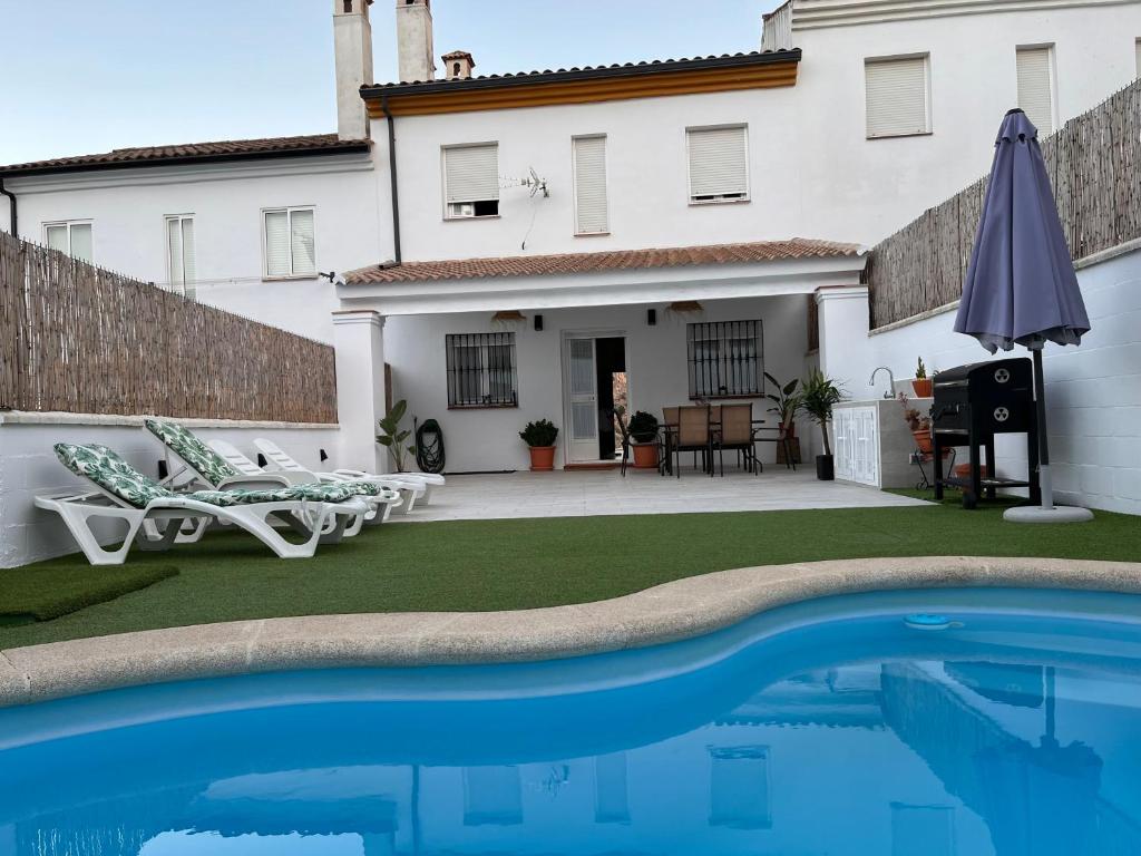 a villa with a swimming pool in front of a house at Mirador de la Ermita in Montejaque