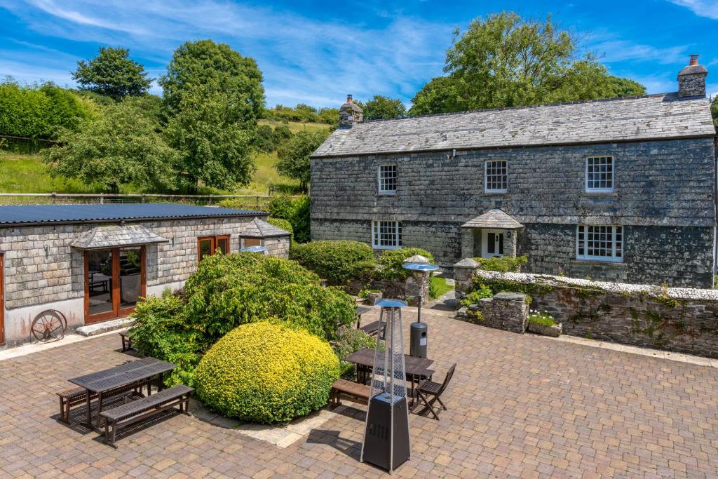 un antiguo edificio de piedra con mesa de picnic y bancos en Ta Mill Cottages & Lodges - Hayloft Cottage en Launceston