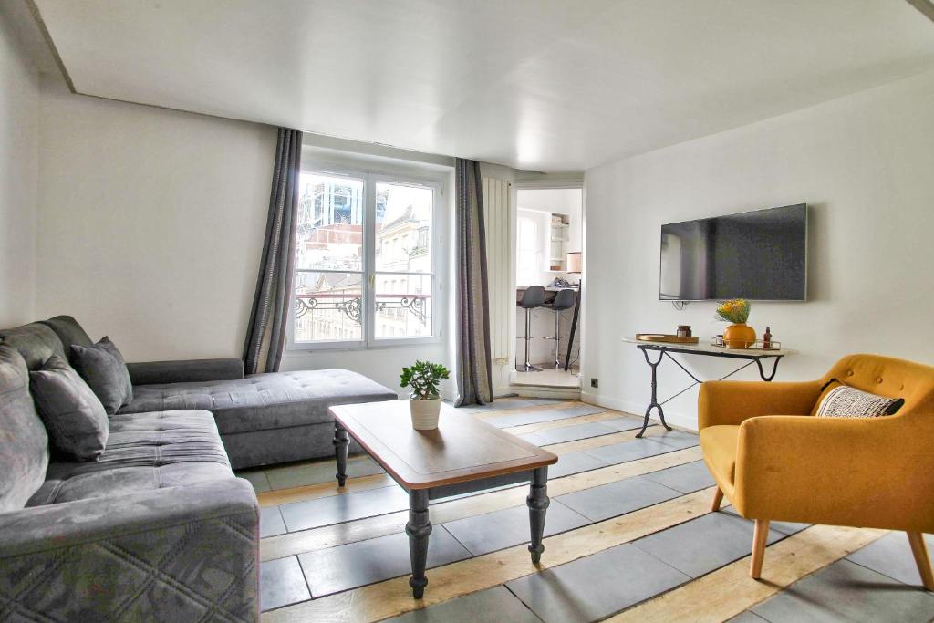 un soggiorno con divano e tavolo di 1 Bedroom Le Marais Temple a Parigi