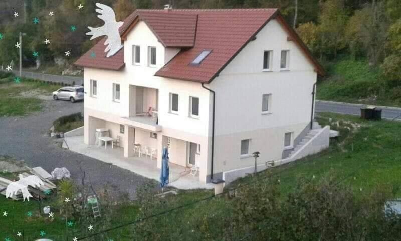 a large white house with a red roof at Sobe pri Roži in Postojna