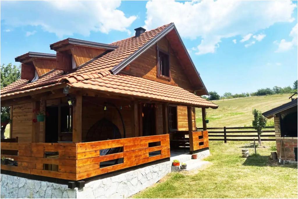 a wooden house with a roof on a field at Kremanski čardak in Kremna