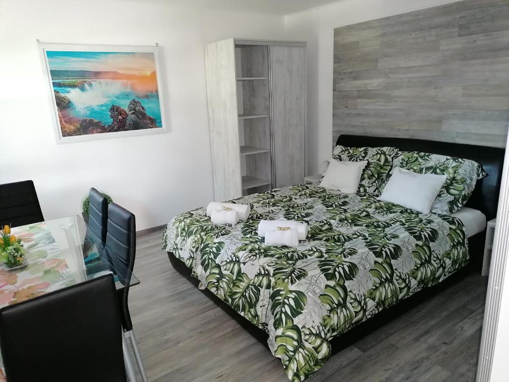 a bedroom with a bed and a table in it at NATA Apartman in Gyula