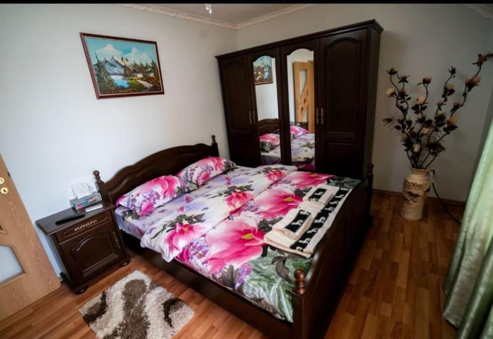 a bedroom with a bed with pink flowers on it at Casa Mona in Oradea