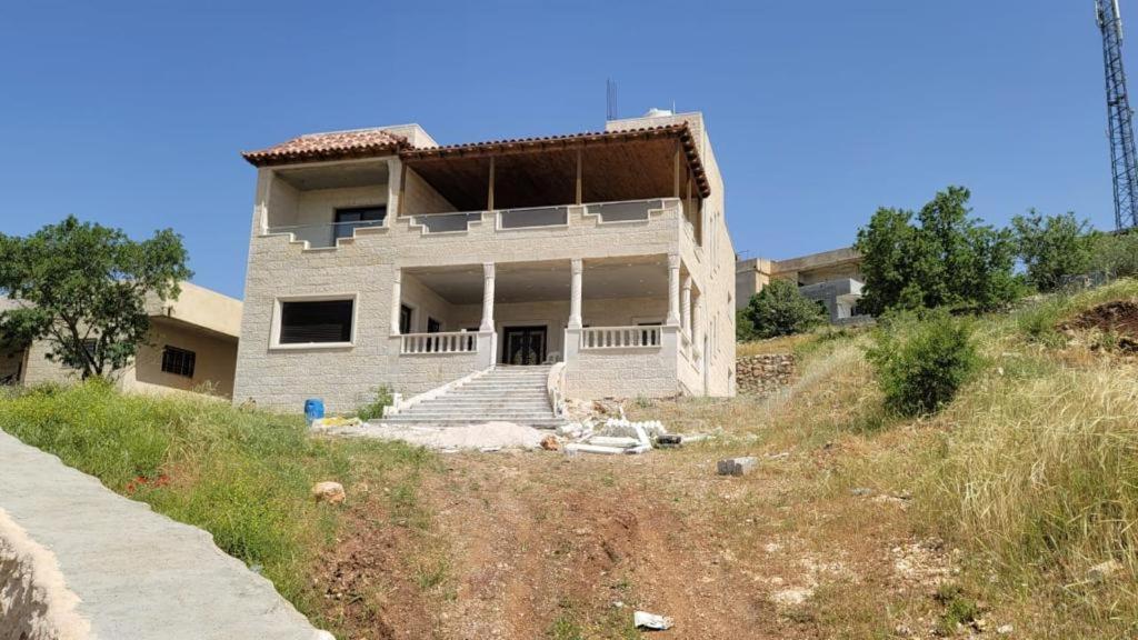 a white house on top of a hill at Furnished house بيت مفروش ابو فارس in Ajloun