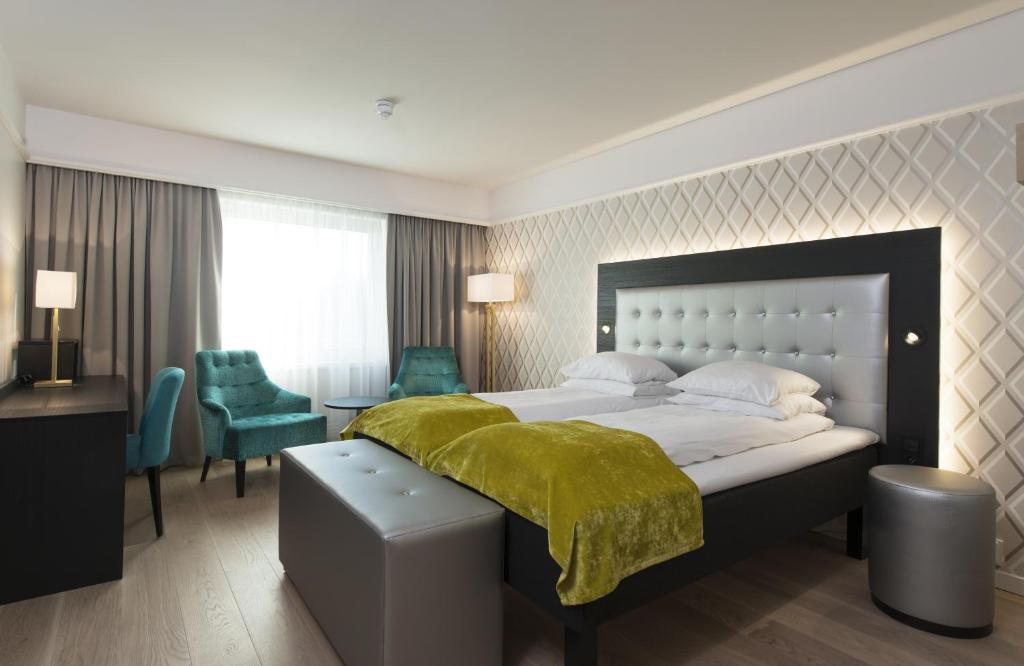 Thon Hotel Oslofjord في ساندفيكا: غرفة نوم بسرير كبير مع بطانية خضراء