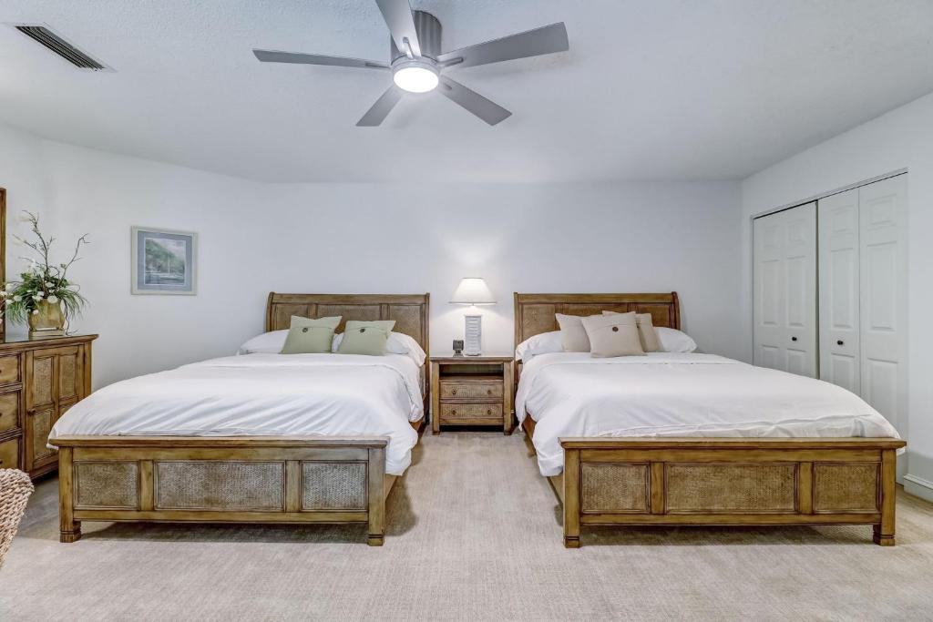a bedroom with two beds and a ceiling fan at Omni Amelia Island Private Room at Courtside Villa-Minutes to Beach and Dining-2358 Boxwood Ln in Fernandina Beach