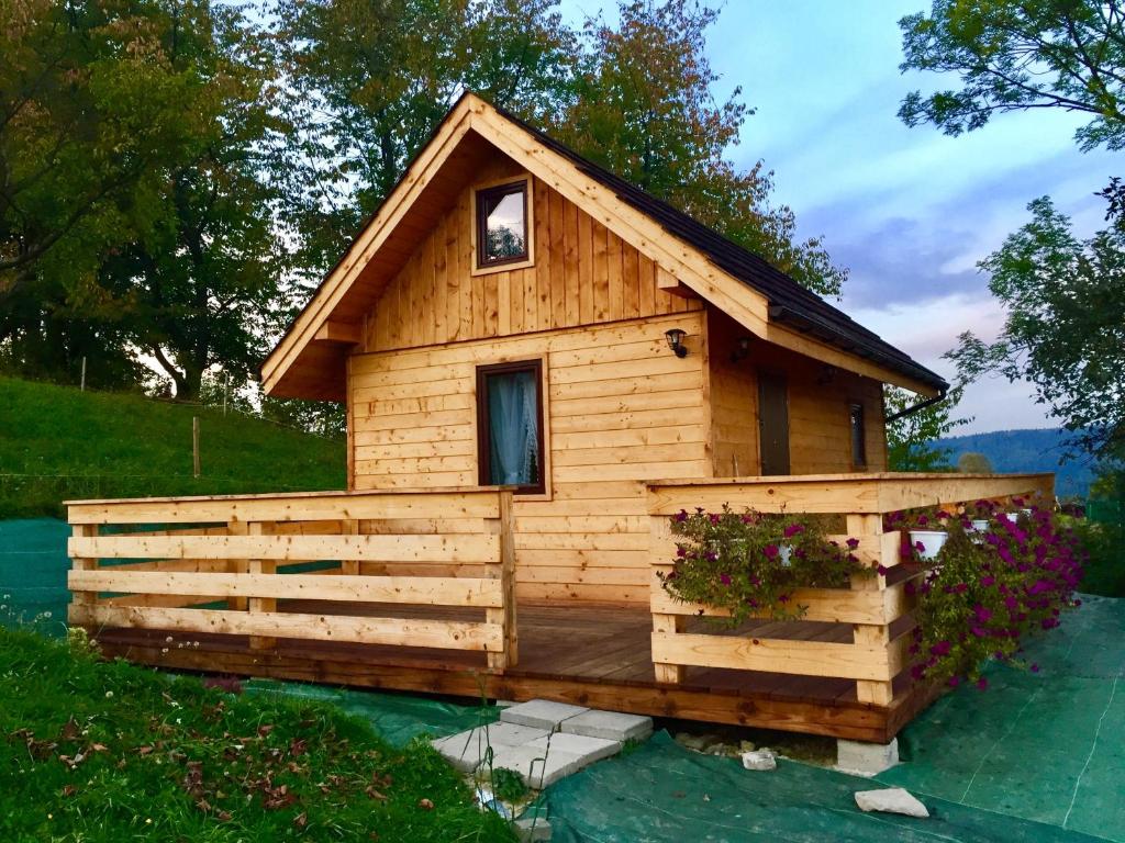 ein kleines Holzhaus mit einem Zaun drum herum in der Unterkunft Mała Aleksandra 
