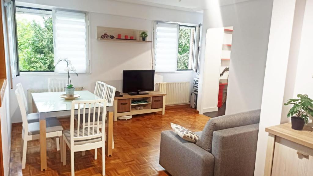 uma sala de estar com uma mesa de jantar e um sofá em Apartamento en San Sebastián con parking em Loyola