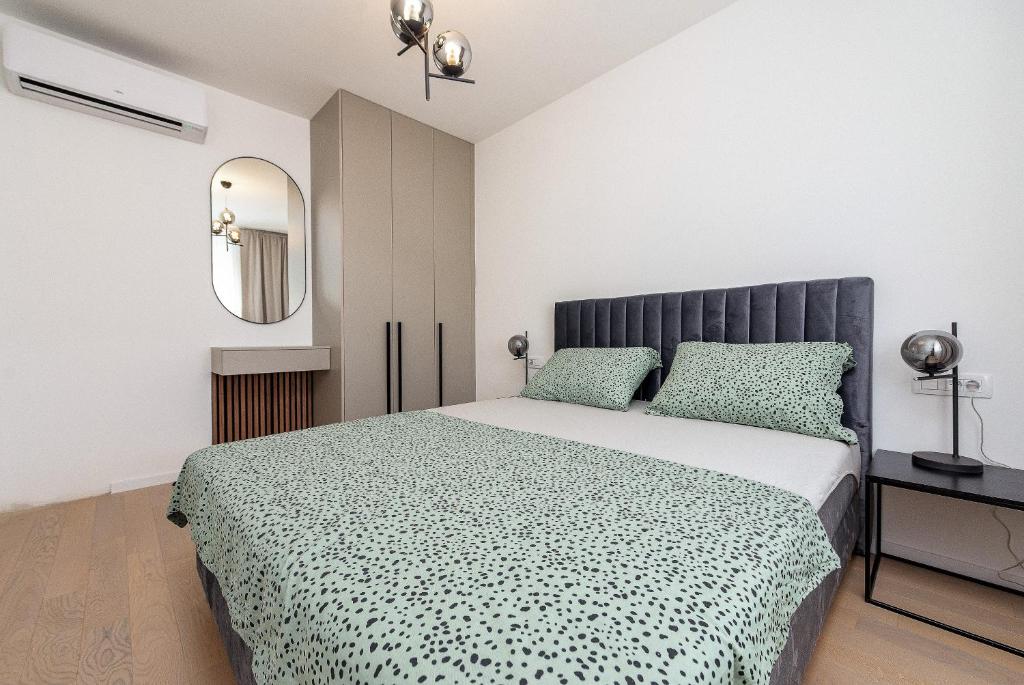 sypialnia z dużym łóżkiem i lustrem w obiekcie City Lux Apartment 2 - with garage and balcony w mieście Zadar