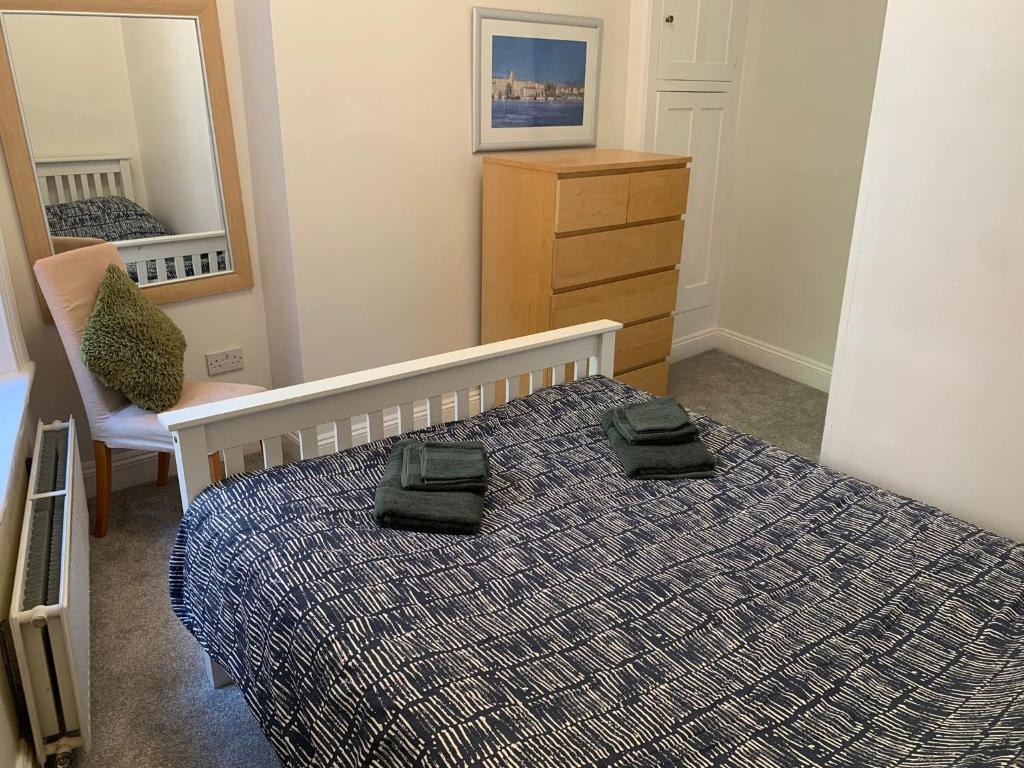 ボーンマスにあるBeachfront Apartment with BBQ Sun Deckのベッドルーム1室(ベッド1台、緑のタオル2枚付)