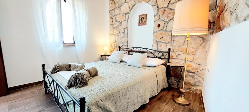 - une chambre avec un lit et un mur en pierre dans l'établissement Hacienda Murter, à Murter