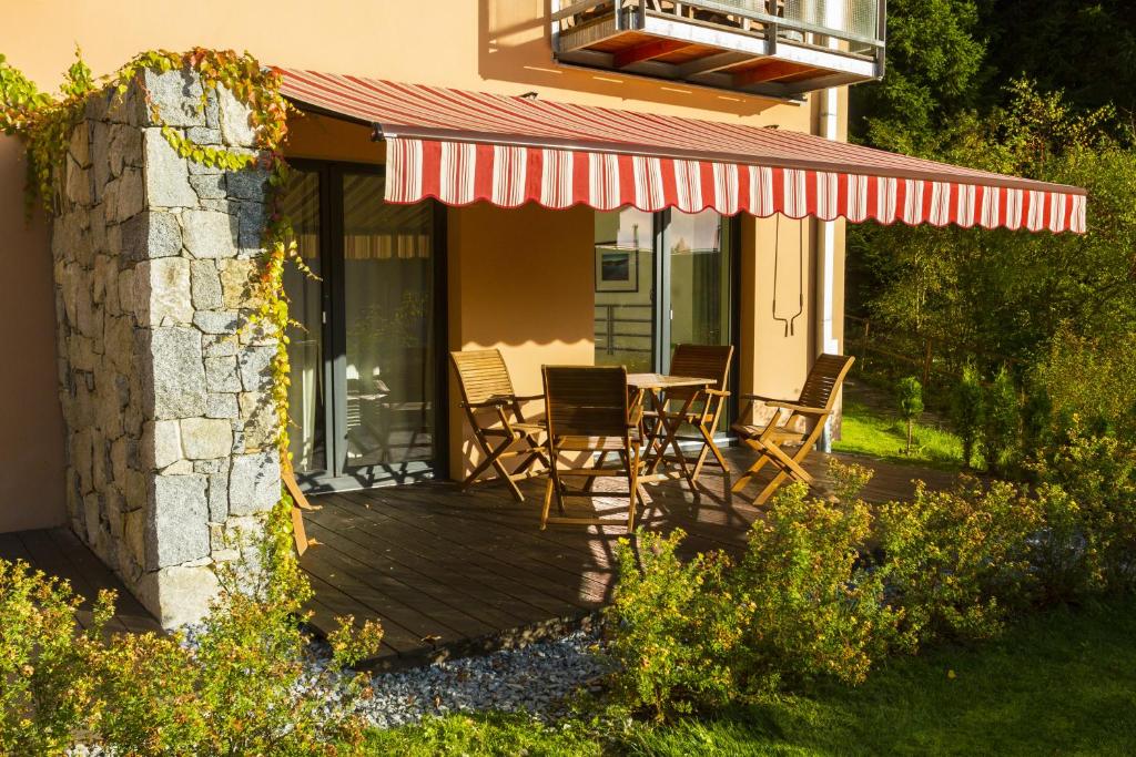 een terras met stoelen en een tafel op een huis bij Lipno 35 - Lipno In in Lipno nad Vltavou