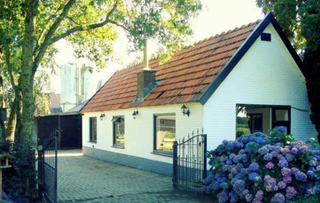 una pequeña casa blanca con techo rojo en 'T Bakhuusje, en Putten